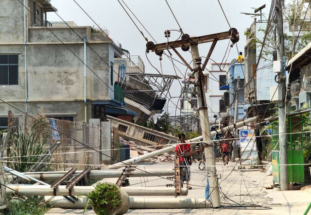 A man examines a downed power line caused by the earthquake in Myanmar.